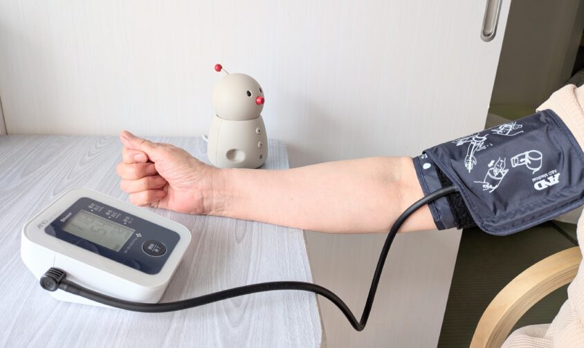 実家で高齢の母が血圧測定をしている様子