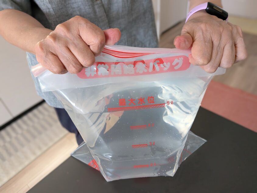 非常用給水バッグのジッパーを閉める様子